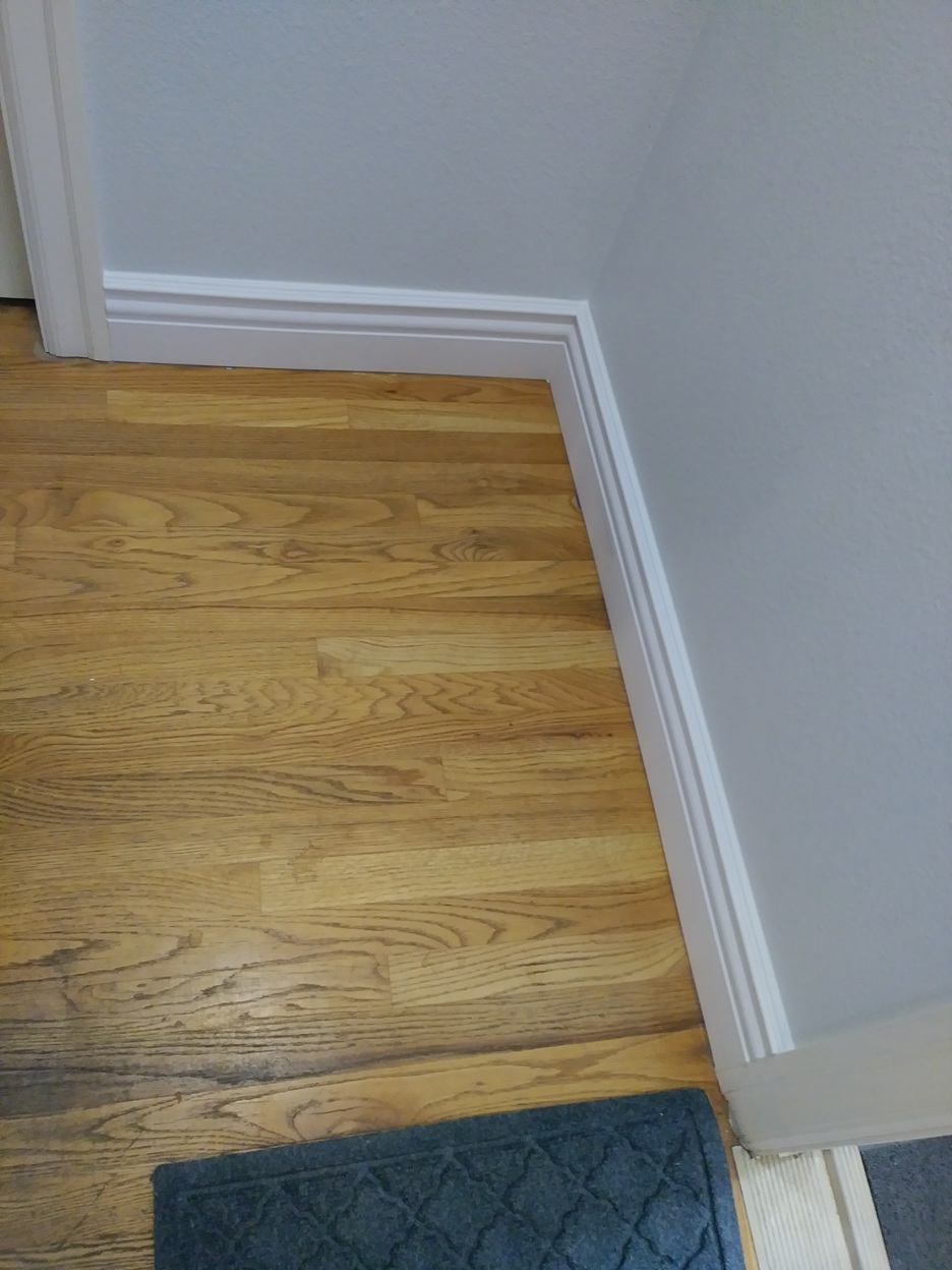 White baseboard trim installed on hardwood floor, Seattle home