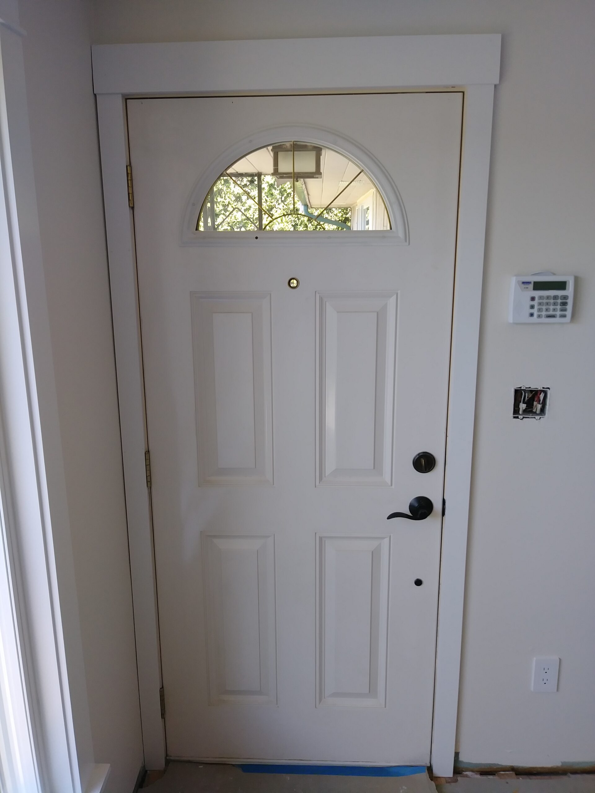 Exterior front door with arched transom casing installed, Seattle home