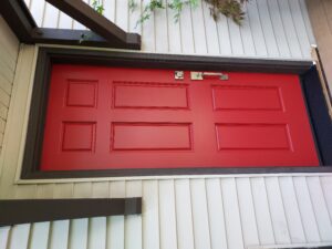 Bold red exterior door installed on white house, Seattle