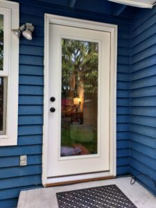 White exterior door with sidelights installed on blue house, Seattle