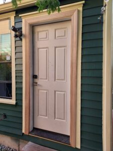 Completed gray exterior door installation on teal house, Seattle