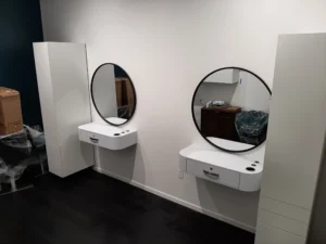 Completed bathroom vanity cabinet installation with round mirrors, Seattle