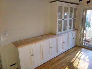 Tall white built-in cabinets with glass doors installed, Seattle home