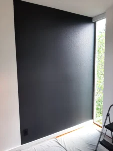 Dark accent wall during vertical wood slat installation, Seattle