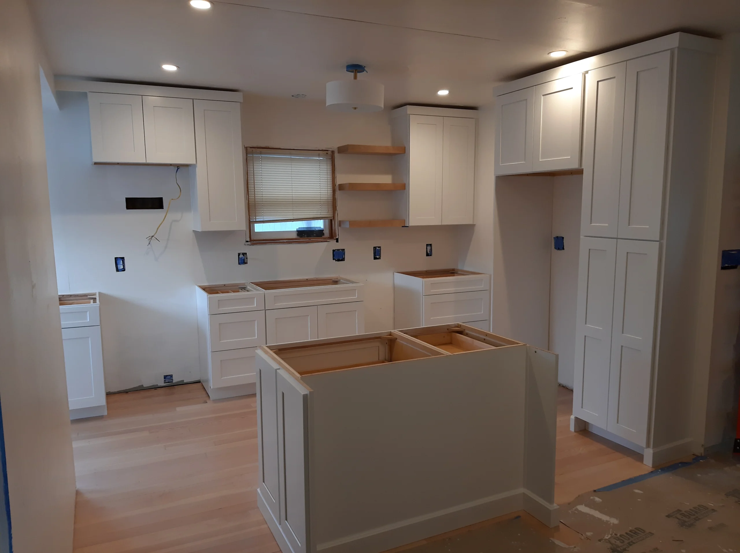 Finished white kitchen with island cabinet installation, Seattle home