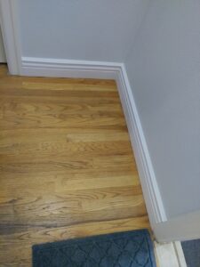White baseboard trim installed on hardwood floor, Seattle home