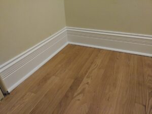 White baseboard installed on hardwood floor, Seattle home